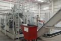 FAUDI Brikettierpresse mit rotem Container in Produktionshalle