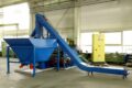 Eine Blaue Brikettierpresse in einer Montagehalle