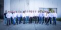 Gruppe von Menschen in Jeans und Hemden gekleidet steht vor grauer Wand / Karriere bei FAUDI